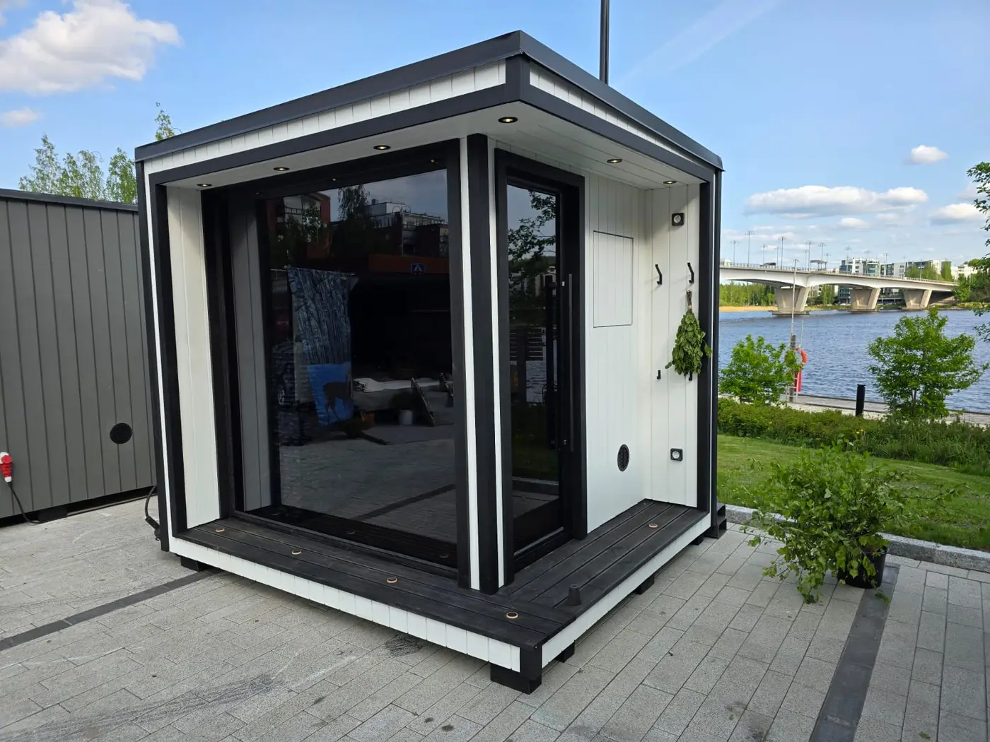 A black-and-white Medium parked on a lakeside promenade